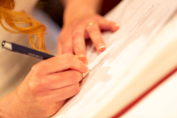 mani di sposa firma atto di matrimonio nella cerimonia cristiana. Foto di alta qualità - Foto, immagini