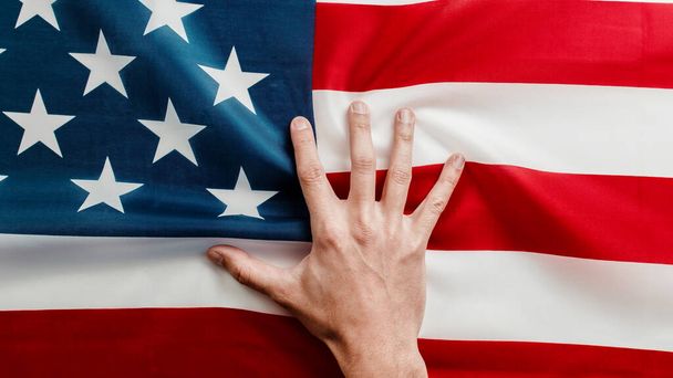 mano sulla bandiera americana da vicino  - Foto, immagini