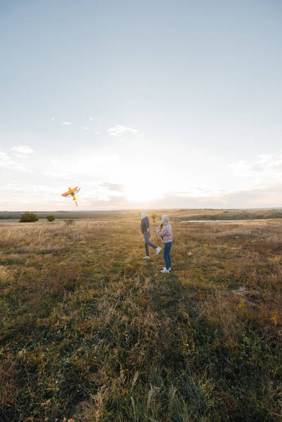 A happy couple flies a kite and spends time together outdoors in a nature reserve. Happy relationships and family vacations. Freedom and space. - Photo, Image