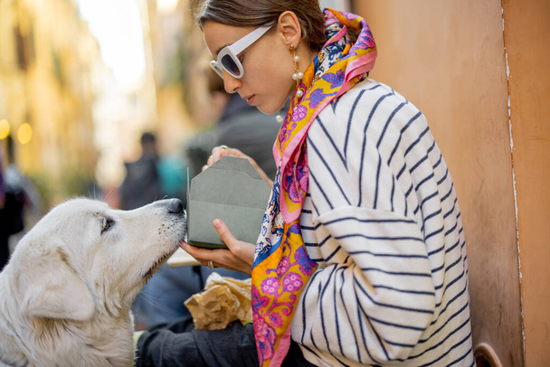 Femme prend soin de son chien tout en mangeant des pâtes au café en plein air - Photo, image