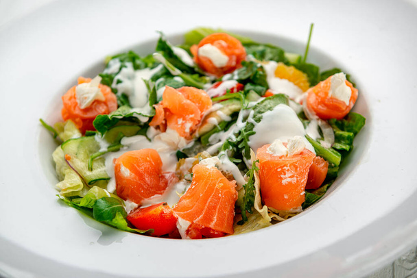 Salade met gerookte zalm, verse groenten en roomkaas. Eten serveren in een restaurant. Foto voor het menu - Foto, afbeelding