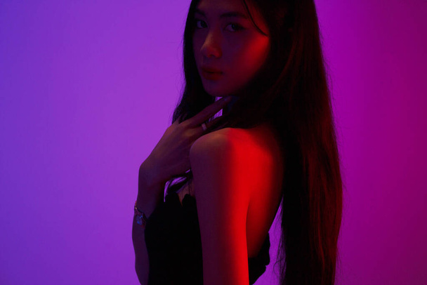 Fashion and beauty concept, Fashion woman is posing with jewelry on neon light background. - 写真・画像
