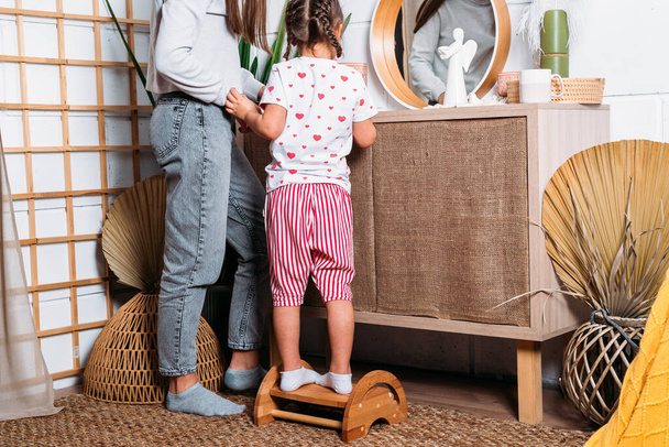 Máma a dcera na dřevěné židli se dívají do zrcadla v pokoji - Fotografie, Obrázek