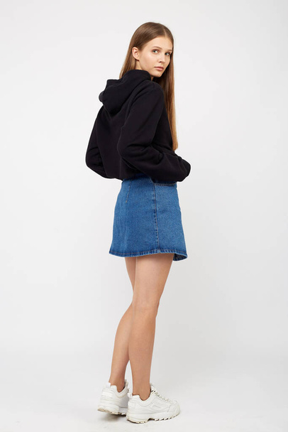 girl in a denim skirt and a black jacket - Foto, afbeelding