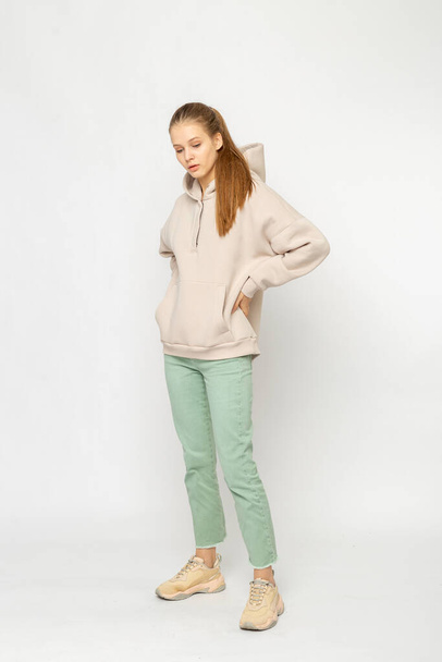 Girl in green cargo pants and beige hoodie isolated on white - Фото, зображення