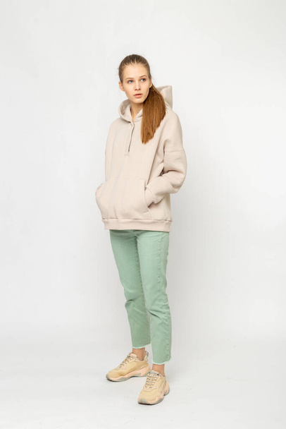 Girl in green cargo pants and beige hoodie isolated on white - Foto, immagini