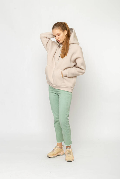 Girl in green cargo pants and beige hoodie isolated on white - Fotó, kép