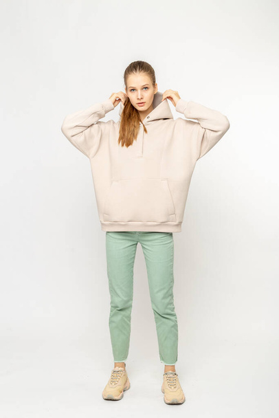 Girl in green cargo pants and beige hoodie isolated on white - Φωτογραφία, εικόνα