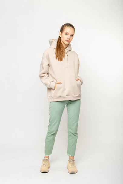 Girl in green cargo pants and beige hoodie isolated on white - Foto, Imagen