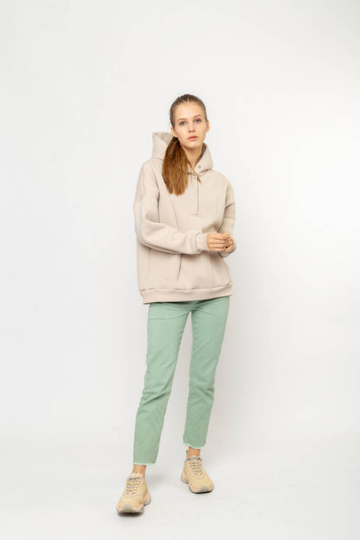 Girl in green cargo pants and beige hoodie isolated on white - Fotografie, Obrázek