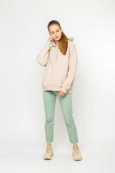 Girl in green cargo pants and beige hoodie isolated on white - Фото, изображение