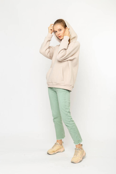 Girl in green cargo pants and beige hoodie isolated on white - Foto, imagen