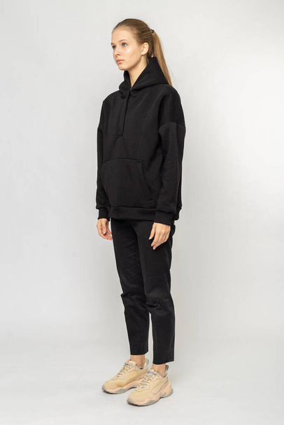 Girl in black cargo pants and black hoodie isolated on white - Fotó, kép