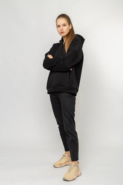 Girl in black cargo pants and black hoodie isolated on white - Fotó, kép