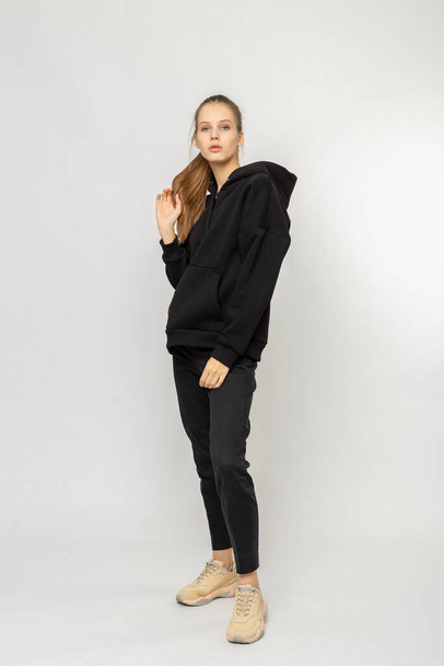 Girl in black cargo pants and black hoodie isolated on white - Foto, immagini