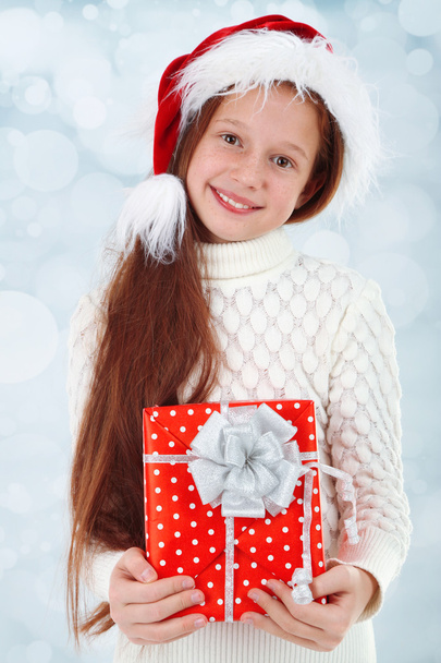 Beautiful little girl with present box on bright background - Zdjęcie, obraz