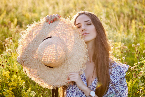 beautiful young girl with a straw hat in nature - Photo, Image