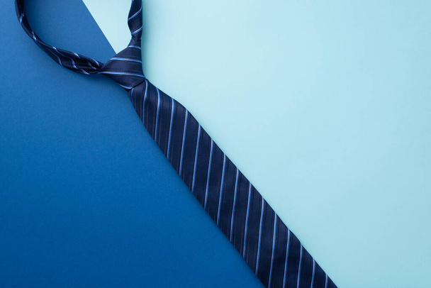 Father's Day concept. Top view photo of blue necktie on bicolor blue background with copyspace - Fotografie, Obrázek