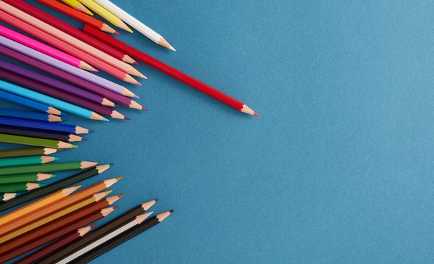 Colored pencils on blue background. - Foto, imagen