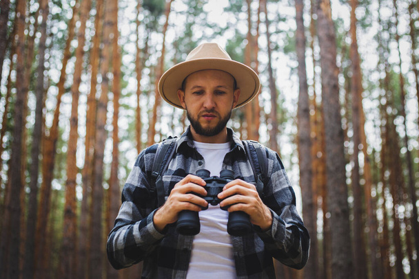 Touriste homme avec jumelles lors de randonnées dans la forêt. Randonnée en montagne ou en forêt. - Photo, image