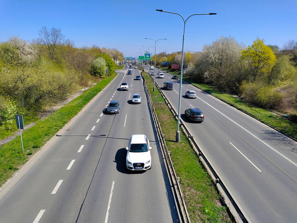 Prag, Tschechische Republik: 23. April 2022 - Autos auf der geraden Autobahn mit Grünstreifen und Straßenlaternen zwischen den beiden Hauptlinien. - Foto, Bild