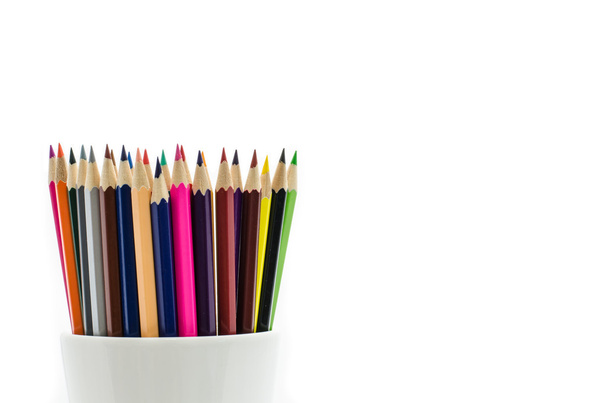 Stack of colored pencils in a glass on white background - Photo, image