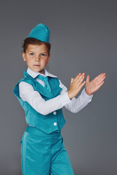 Cute little girl in blue stewardess uniform is posing for the camera. - Фото, изображение