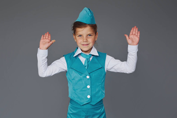 Cute little girl in blue stewardess uniform is posing for the camera. - Valokuva, kuva