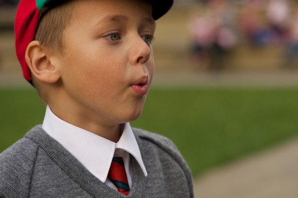 Close-up of uniformed schoolboy blowing out cheeks - Photo, Image
