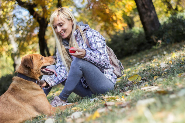 Positive young woman enjoying happy moments with her dog - Foto, Imagem