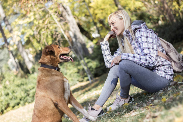 Mujer joven positiva disfrutando de momentos felices con su perro - Foto, Imagen