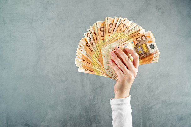 Woman holding fifty euros stack - Foto, imagen