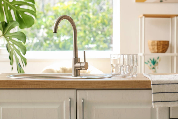 Sink and empty glasses on counter in kitchen - Photo, Image