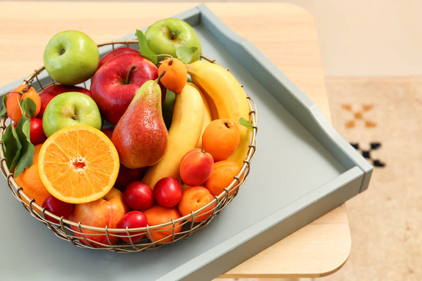 Tray with fruit basket on wooden table, closeup - 写真・画像