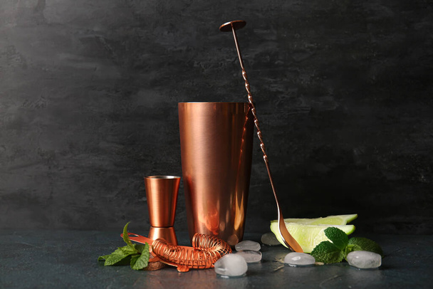 Set aus Kupfer-Cocktail-Utensilien und Zutaten auf dunklem Hintergrund - Foto, Bild