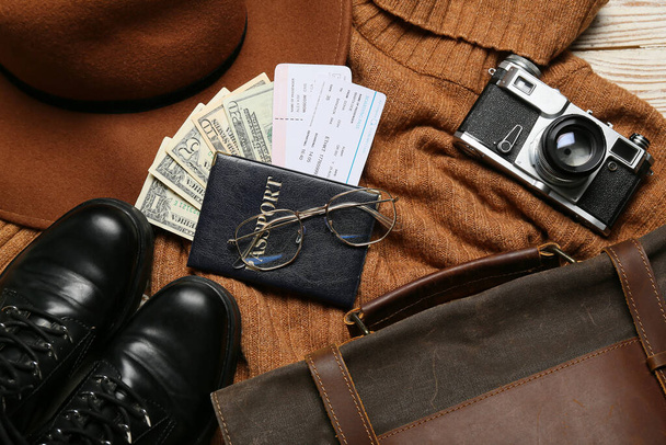 Passeport avec argent, billets, appareil photo et effets personnels du guide sur fond de bois clair - Photo, image