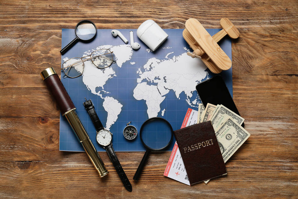 Guide's belongings with world map and magnifiers on wooden background - Photo, Image