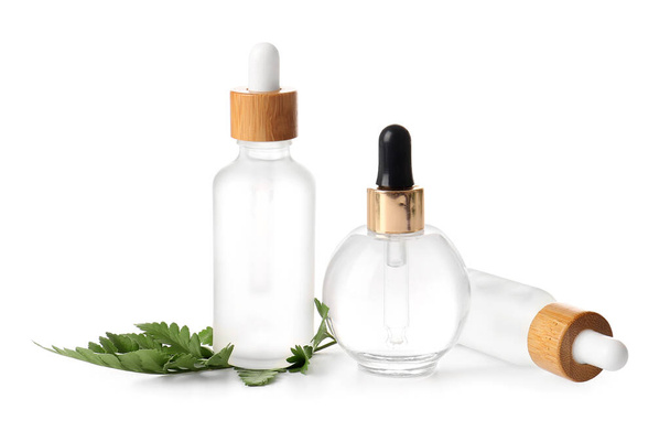 Beyaz zemin üzerinde doğal serum ve eğreltiotu yaprağı şişeleri - Fotoğraf, Görsel