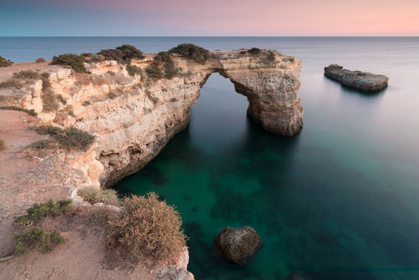 Arco naturale sopra l'oceano. Grotte naturali sulla spiaggia di Marinha, Algarve, Lagoa Portogallo. Arco in pietra sulla spiaggia. Stagione estiva. - Foto, immagini