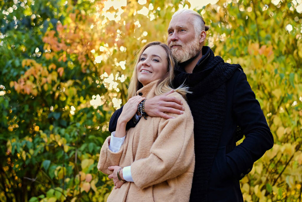 Pár idős férfi és fiatal nő ősszel - Fotó, kép
