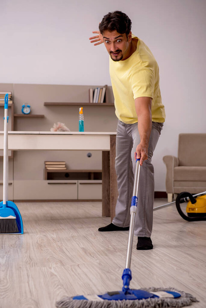 Young man doing housework at home - 写真・画像
