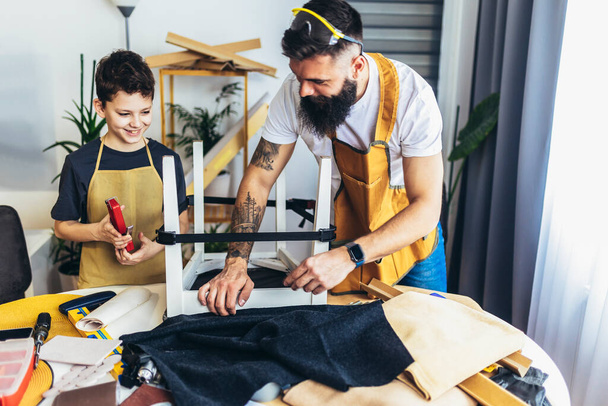 Alegre carpintero joven y su hijo trabajando en el taller - Foto, Imagen