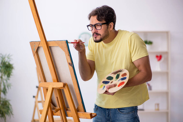 Young man enjoying painting at home - Foto, Bild