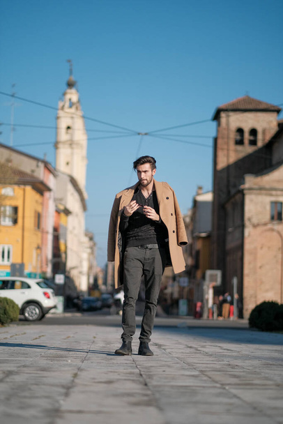 Yakışıklı İtalyan çocuk Parma 'nın tarihi merkezinde paltosuyla yürüyor. Yüksek kalite fotoğraf - Fotoğraf, Görsel