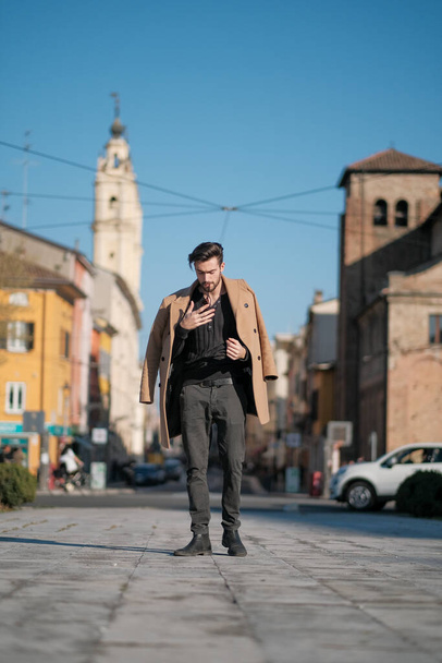 handsome Italian boy walks with coat in the historic center of Parma. High quality photo - Photo, image