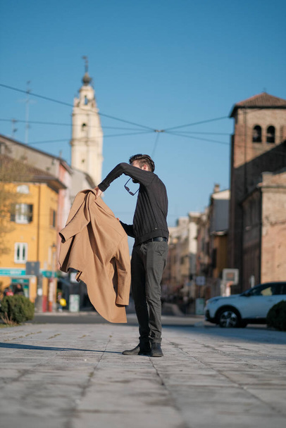 handsome Italian boy walks with coat in the historic center of Parma. High quality photo - Foto, Imagem