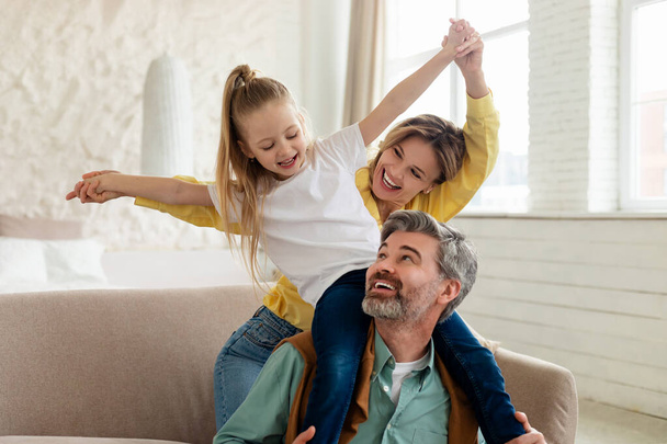 familia feliz divertirse, padre celebración hija en hombros interior - Foto, imagen