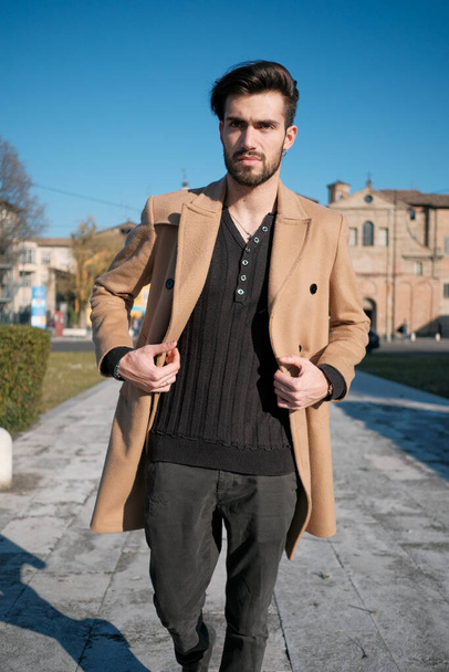 chico italiano guapo camina con abrigo en el centro histórico de Parma. Foto de alta calidad - Foto, imagen
