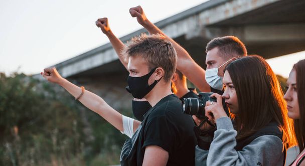 Photographer with camera. Group of protesting young people that standing together. Activist for human rights or against government. - Φωτογραφία, εικόνα