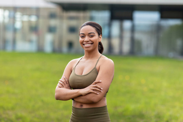Портрет щасливої молодої чорної жінки в спортивному вбранні позує в міському парку
 - Фото, зображення